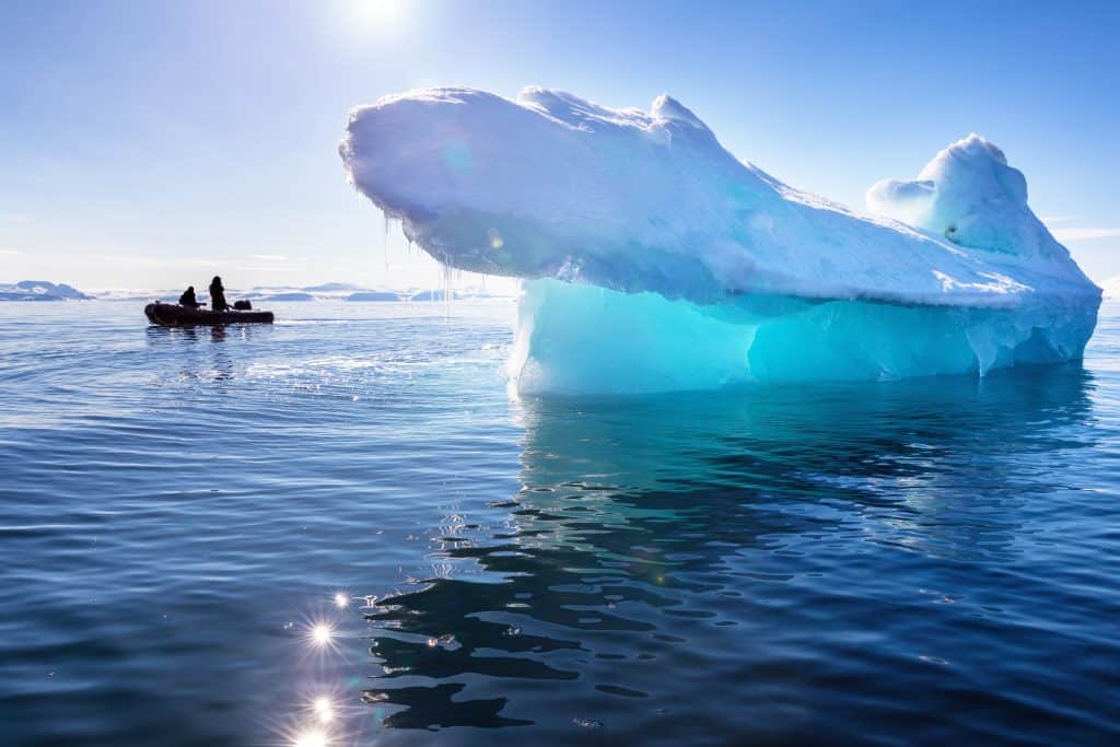 Rubberboot bij een blauwe ijsberg in Spitsbergen
