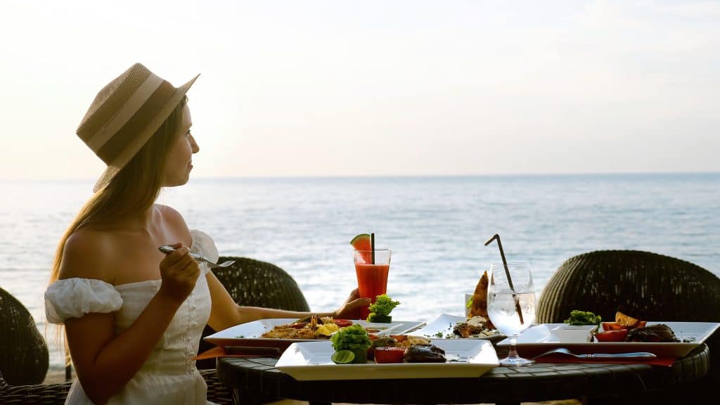 Vrouw aan het eten met uitzicht op zee